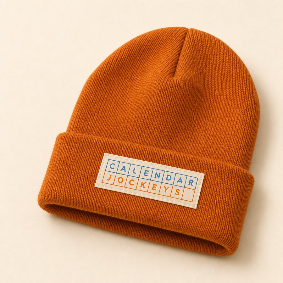 Burnt orange knit beanie with a woven grid wordmark label